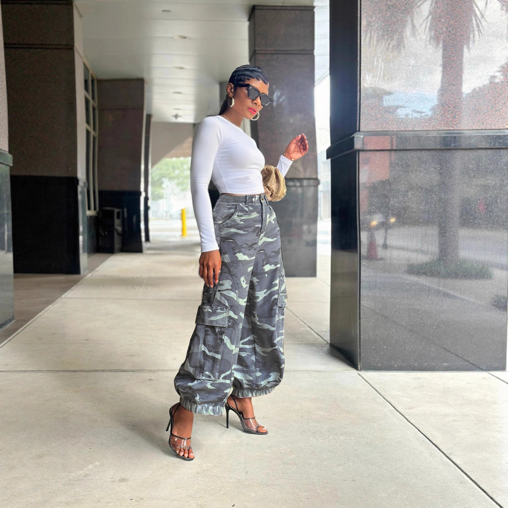 side profile lifestyle shot, styled with white long sleeve crop top, gold mini bag, and strappy heels on urban walkway